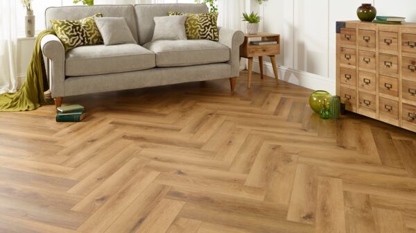 Living room featuring herringbone patterned flooring and a gray sofa